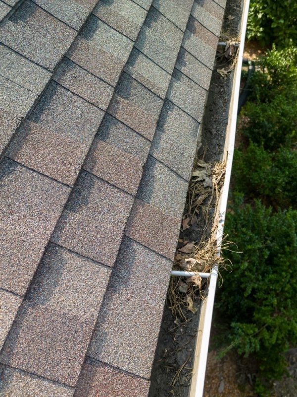Metal,Gutters,Clogged,With,Leaves,And,Debris,On,A,Red Metal,Gutters,Clogged,With,Leaves,And,Debris,On,A,Red